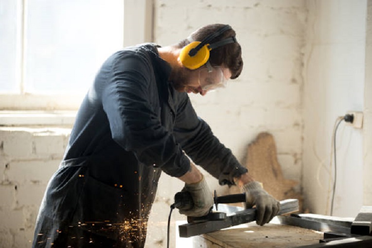 woodworker in workshop using hearing protection equipment